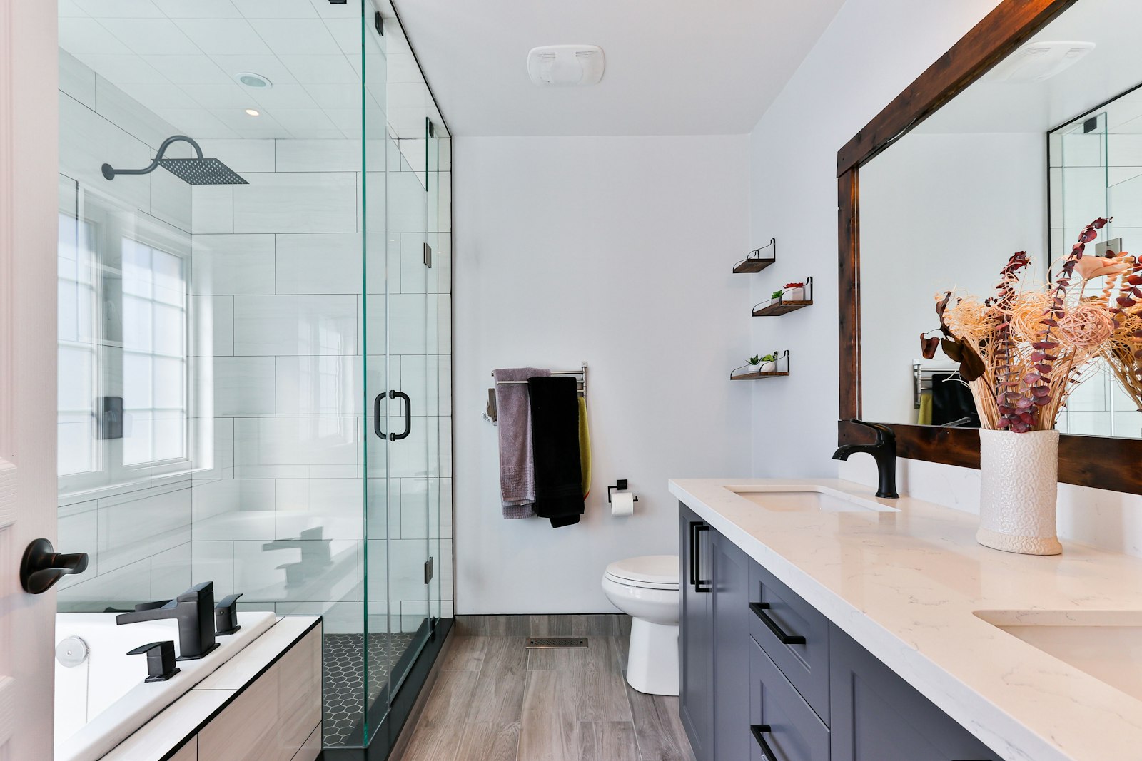 Renovated primary bathroom with glass shower and double vanity